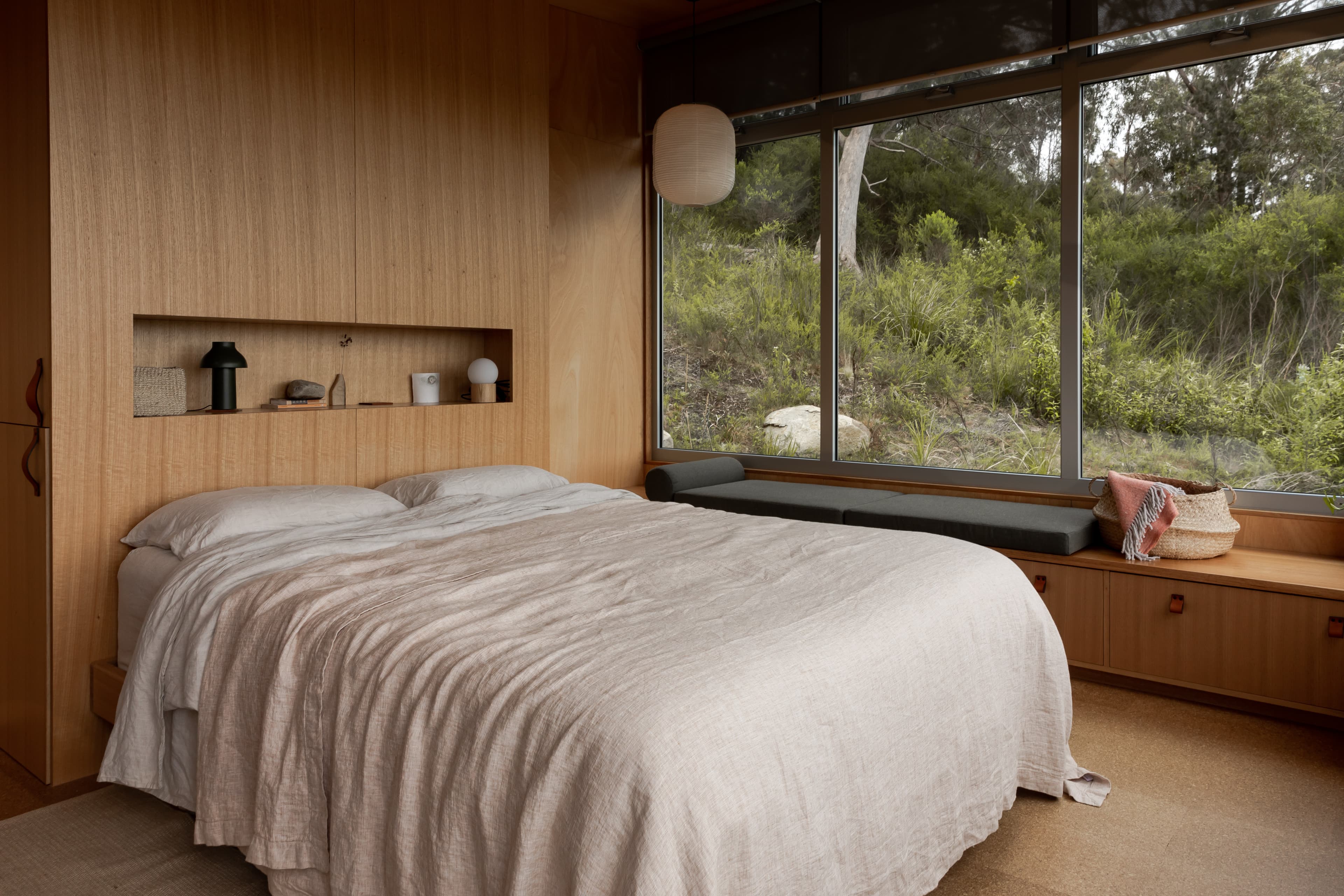 Linen-dressed bed beside a long bush window