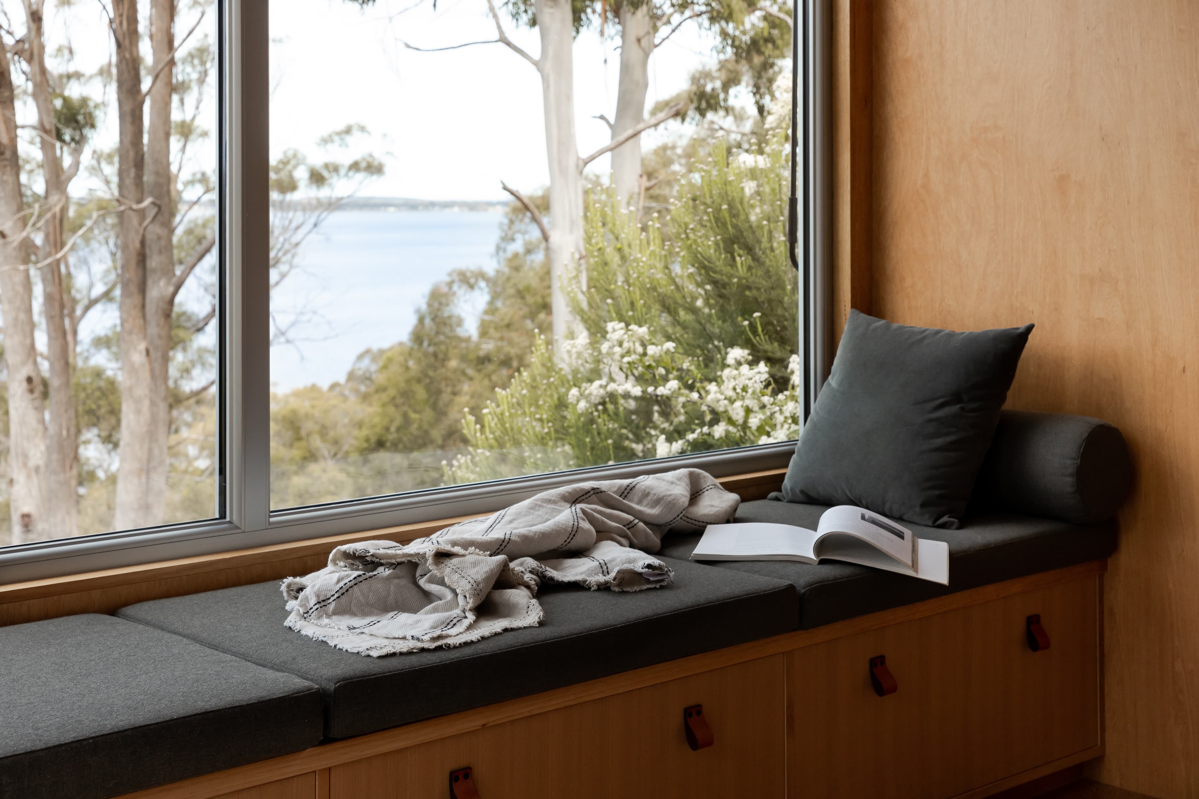 Window seat with an open book and view of Georges Bay